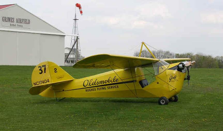 Aeronca-C-3 parked in front of a hangar at Grimes Airfield